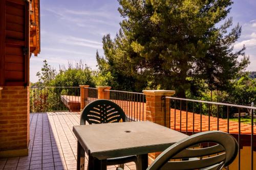 a table and chairs on a patio with a fence at Casa Jo - Country Home with Sea View and 3 Private Ensuite Rooms in Lapedona