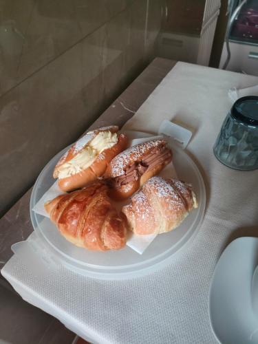 three pastries on a white plate on a table at Malva B&B in Reggio Calabria