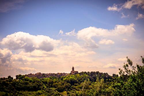 a building on top of a hill with trees at Casa Jo - Country Home with Sea View and 3 Private Ensuite Rooms in Lapedona