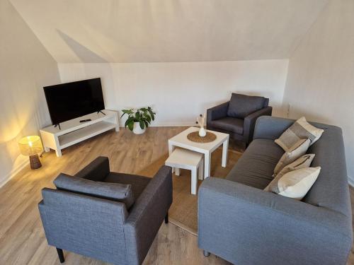 a living room with two couches and a tv at Ferienwohnung Wiese in Langelsheim