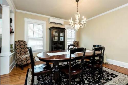 a dining room with a table and chairs and a chandelier at Historic Row Home 1 Block from Gate 1 at USNA in Annapolis