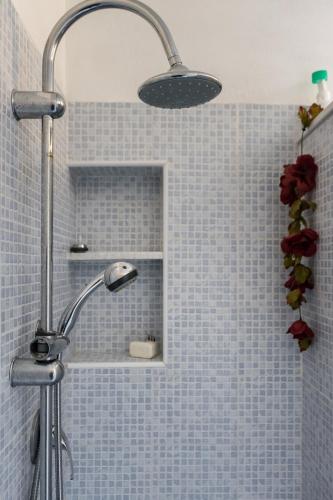 a shower with a shower head in a bathroom at The Peacock house in Flumini di Quartu