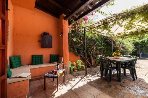 a patio with a table and chairs and a couch at The Peacock house in Flumini di Quartu