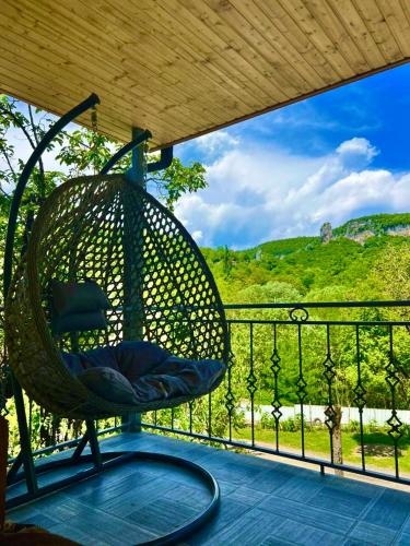 a swinging chair on a porch with a view at Butichi Guest House in Chiatʼura