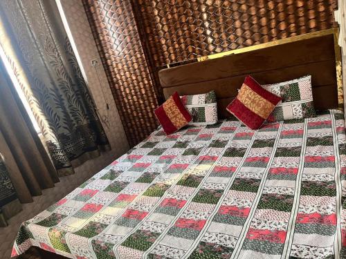 a bed with a quilt and pillows on it at Arora guest house in Amritsar
