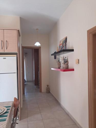 a kitchen with a table and a white refrigerator at Liberty Cozy Apartment in Kalloni