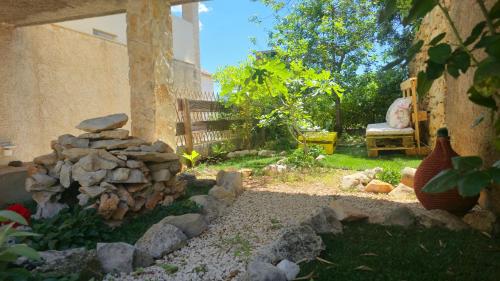 a garden with a pile of rocks and a bench at Studio apartments Kali in Kali