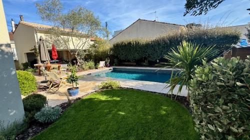 une cour avec une piscine et une pelouse dans l'établissement Appartement de charme avec accès piscine, à Talence