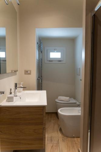 a bathroom with a sink and a toilet and a mirror at Casa Dogana Apartment in Gallipoli