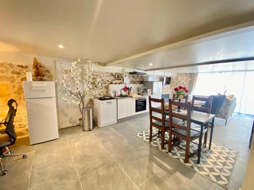 a kitchen and dining room with a table and chairs at Maison des Vignes avec ménage, draps et serviettes inclus in Tabanac