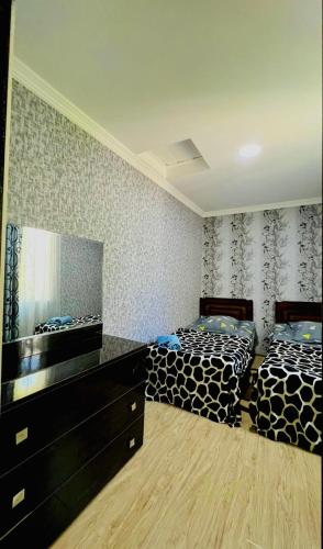 a bedroom with two beds and a dresser in it at Butichi Guest House in Chiatʼura