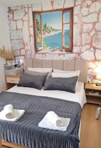 a bedroom with a large bed with a window at Traditional town house in Zastražišće