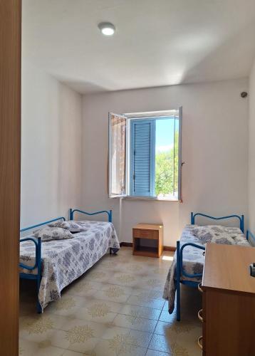 a bedroom with two beds and a window at Casa Celeste in Budoni