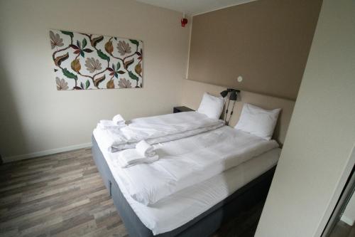a bed in a room with white sheets and pillows at Lycksele Inn in Lycksele