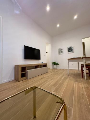 Una sala de estar con un televisor de pantalla plana y una mesa. en Casa Vacanza Dante 17 Carini, en Carini