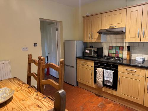 a kitchen with a stove and a refrigerator at Garden View in Great Malvern
