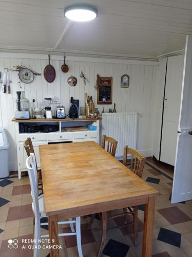 une cuisine avec une table et des chaises en bois dans l'établissement Cancale - Dans le Bourg, à Cancale