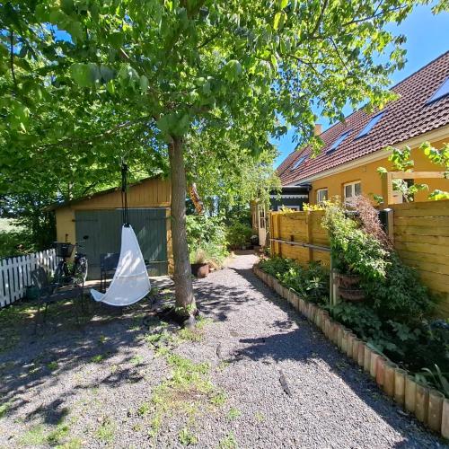 a hammock hanging from a tree in a yard at The Cherry Apartment - 'Den Gule Svane' Guest House near Rønne & Beach in Rønne