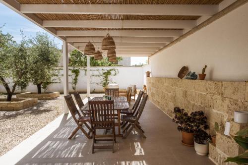 a patio with a table and chairs and a wall at Ella Stays in Santa Maria al Bagno