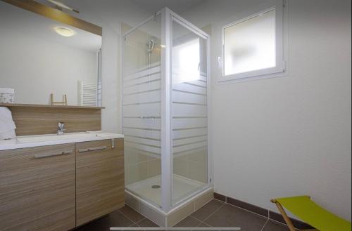 une salle de bain avec une douche en verre et un lavabo dans l'établissement Appartement Lumineux et Calme, à Capbreton