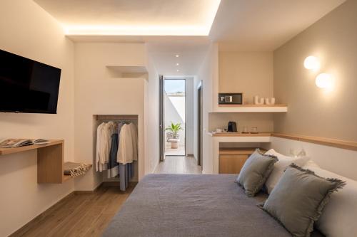 a bedroom with a bed and a tv on a wall at Ella Stays in Santa Maria al Bagno