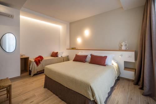a hotel room with two beds and a mirror at Ella Stays in Santa Maria al Bagno