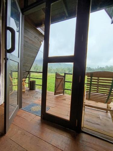 an open door to a porch with a view at The wilds Sinharaja in Deniyaya