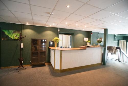 a large room with a counter and green walls at Lycksele Inn in Lycksele