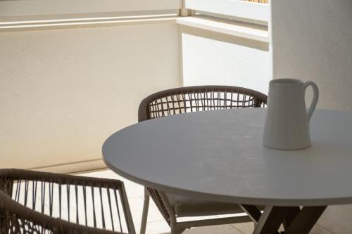 a white table with two chairs and a vase on it at Ella Stays in Santa Maria al Bagno