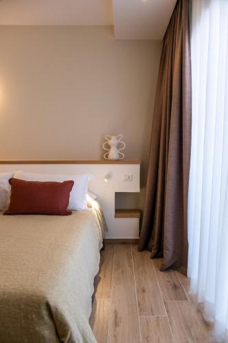 a bedroom with a bed and a large window at Ella Stays in Santa Maria al Bagno