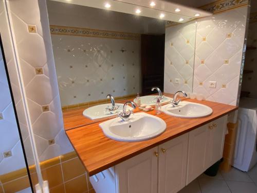 a bathroom with two sinks and a wooden counter at Domaine Rossignol Tournesol in Gourdon-en-quercy