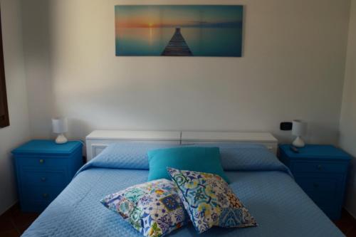 Un dormitorio con una cama azul con dos almohadas. en Casa vacanza Annameri, en Terrasini