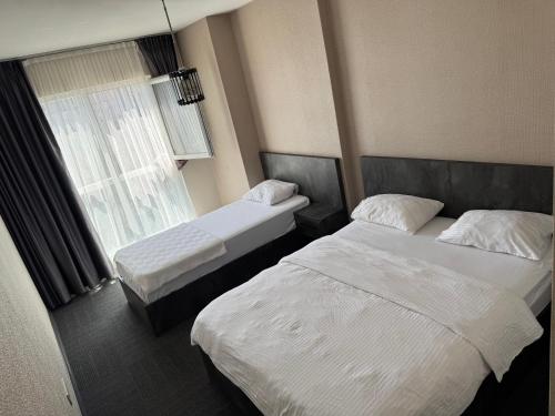 a hotel room with two beds and a window at Pin Suite in Buyukcekmece