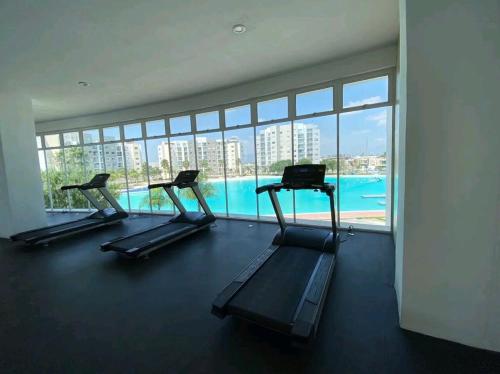a gym with three treadmills and a swimming pool at Increible Apartment with beach Monterrey/Apodaca in Monterrey