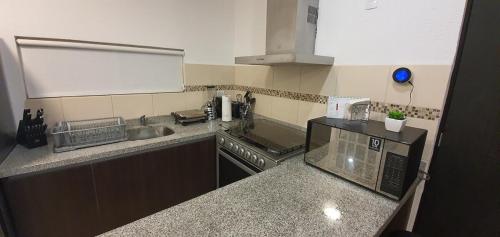 a kitchen with a sink and a stove top oven at Increible Apartment with beach Monterrey/Apodaca in Monterrey