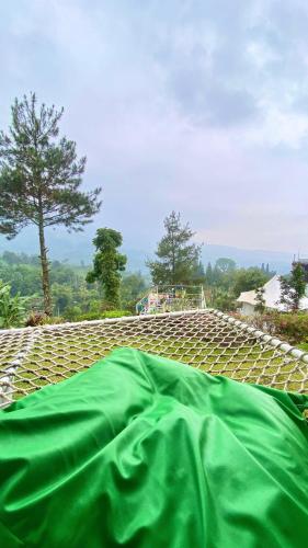 a green sheet laying on top of a roof at De Pointé Resort & Resto in Campaka