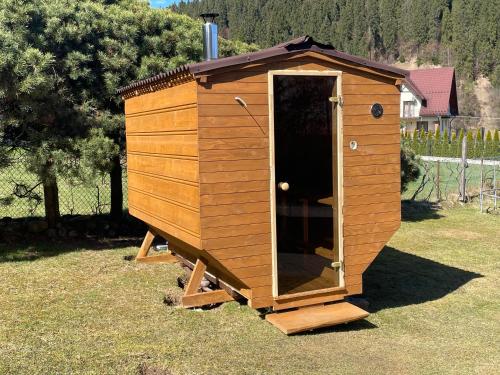 a wooden dog house sitting in the grass at Winnica Spisz in Łapsze Niżne