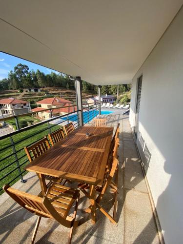 a wooden table and chairs on the balcony of a house at Casa da Boucinha in Celorico de Basto