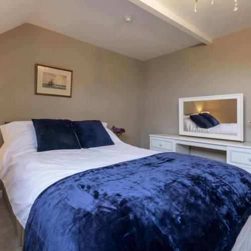 a bedroom with a large bed and a mirror at The Exeter Arms in Barrowden