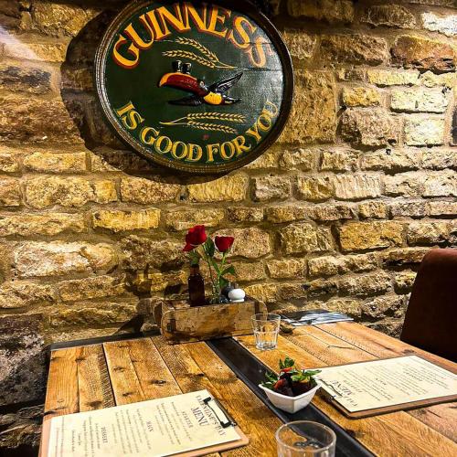 a wooden table with a sign on a brick wall at The Exeter Arms in Barrowden