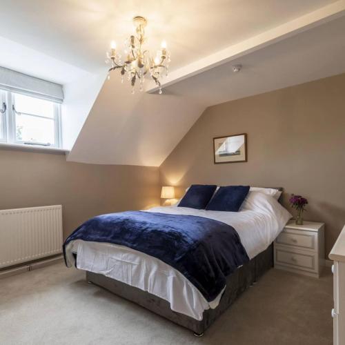 a bedroom with a large bed and a chandelier at The Exeter Arms in Barrowden