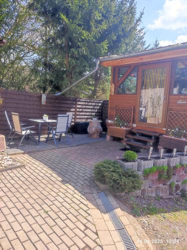 a patio with a table and chairs and a cabin at Ferienwohnung am Schloss in Stolberg i. Harz