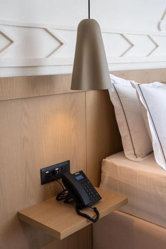 a phone is on a table next to a bed at Hotel Skanderbeg in Golem
