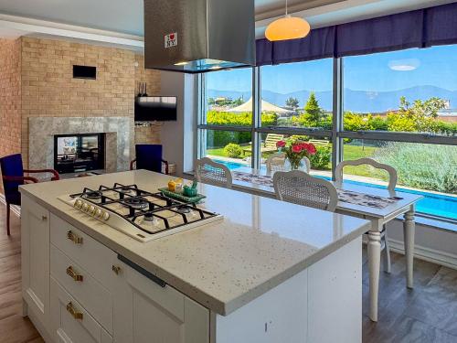 a kitchen with a stove top oven next to a window at Villa Limon in Kuşadası