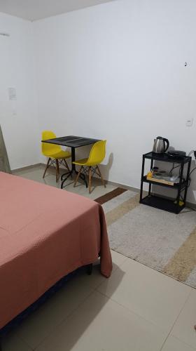 a bedroom with a table and two chairs and a table with at Suite com garagem 900 metros do Mar in João Pessoa