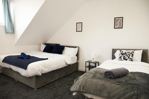 a bedroom with two beds and a chair in it at West Yorkshire Stay - Heart of Leeds in Roundhay