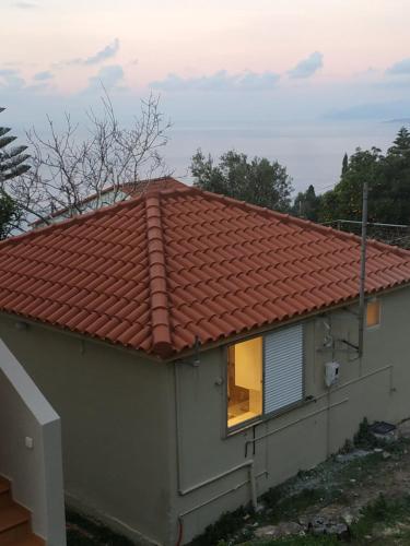 a house with a red roof with a window at Sofias house at Agkona Kefalonia in Angón