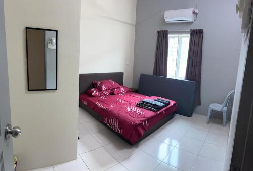 1 dormitorio con 1 cama con edredón rojo y ventana en RB Homestay Modern Comfort, en Hutan Melintang