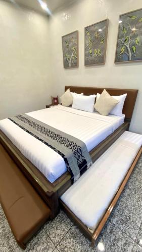 two beds sitting next to each other in a room at De Pointé Resort & Resto in Campaka