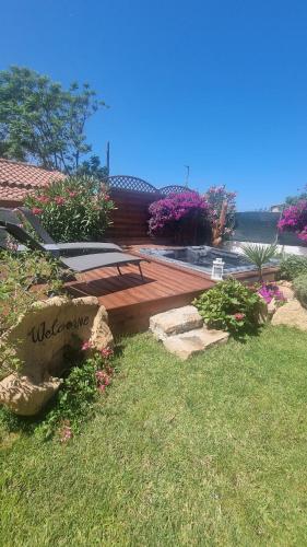 a wooden deck with a bench in a yard at Betty vacanze in Badesi